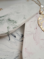 Close-up of a gold earring on a marble surface